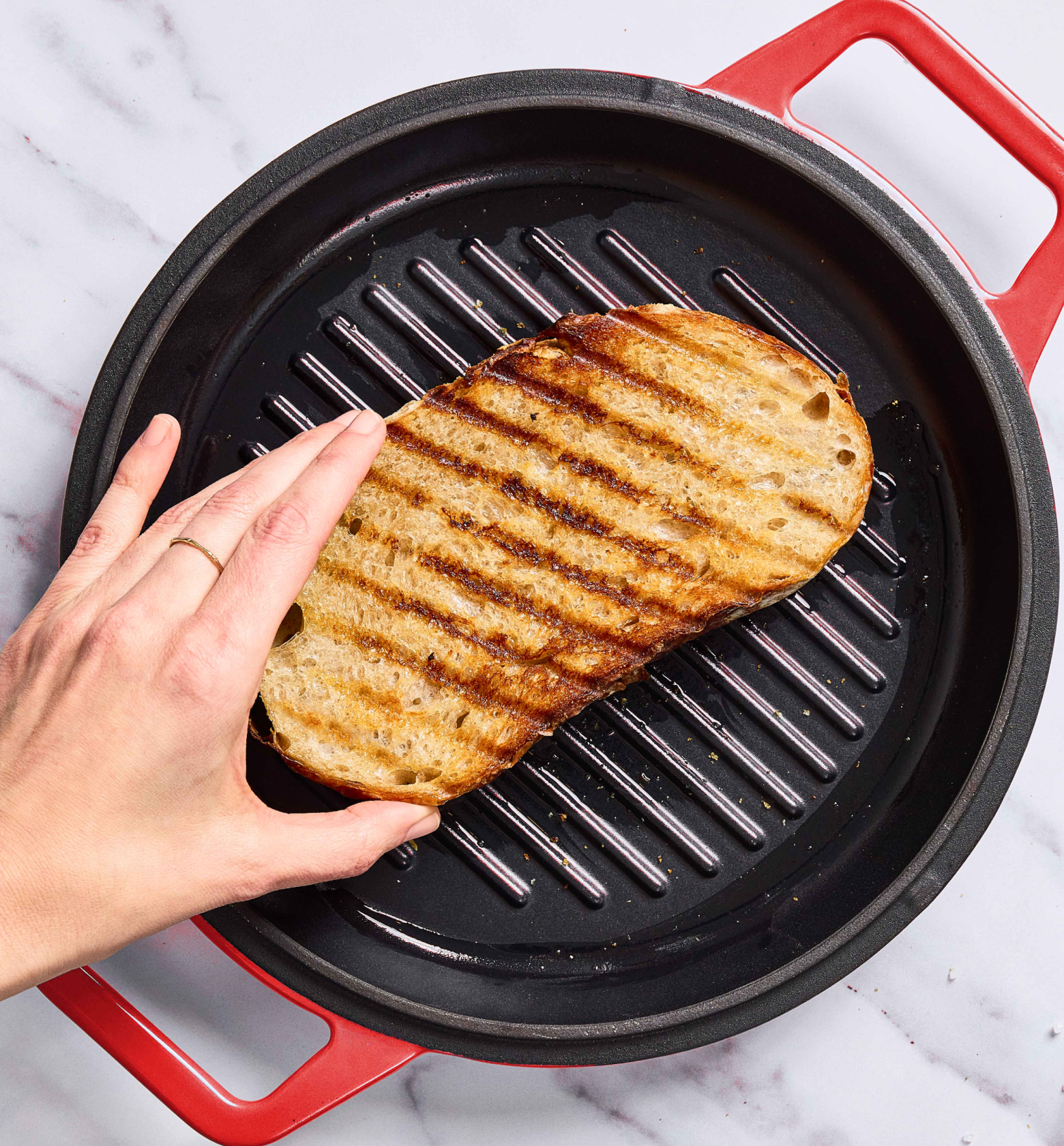 Grilling sourdough bread slice on cast iron grill pan with char marks